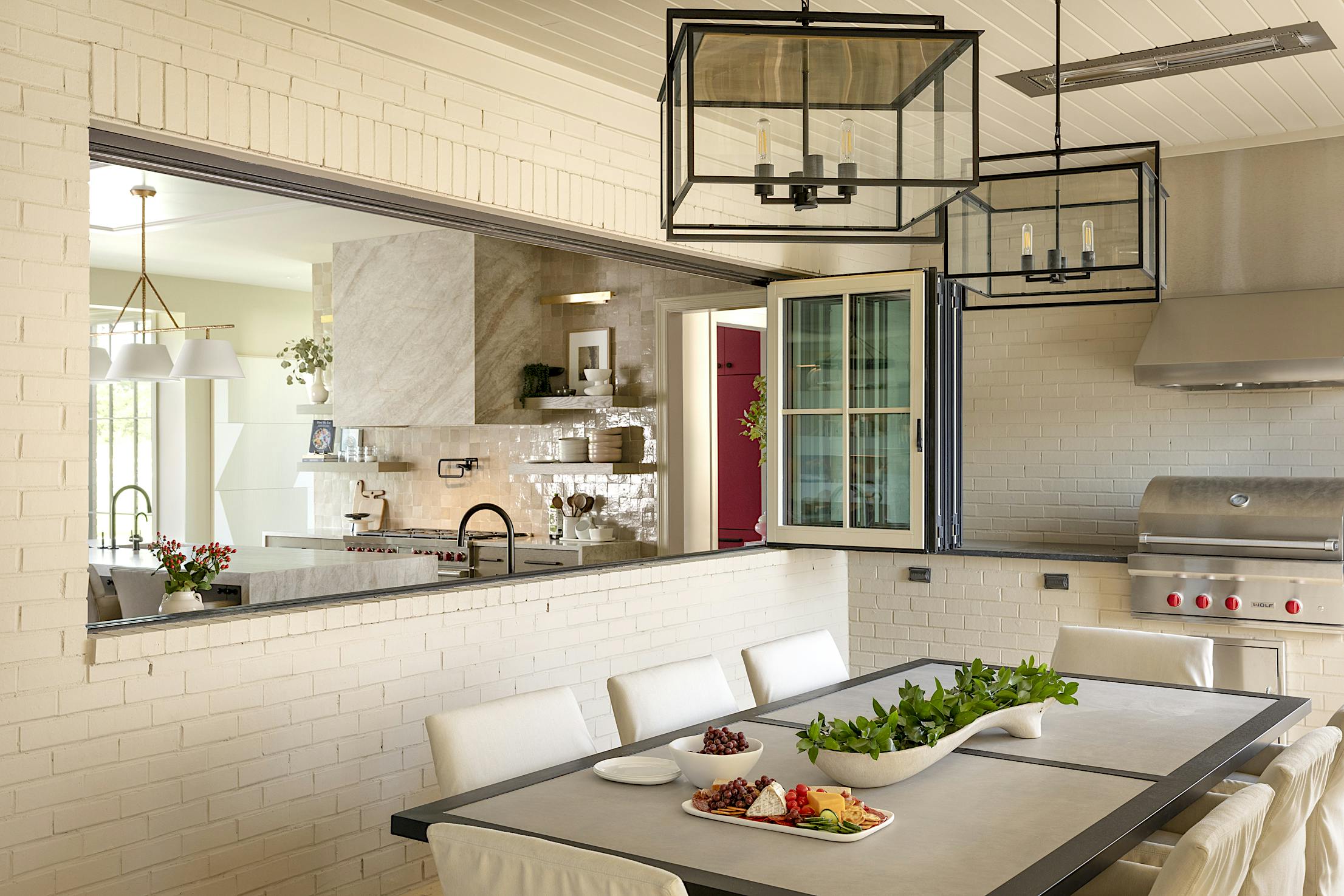 A kitchen with glass walls and a table and chairs