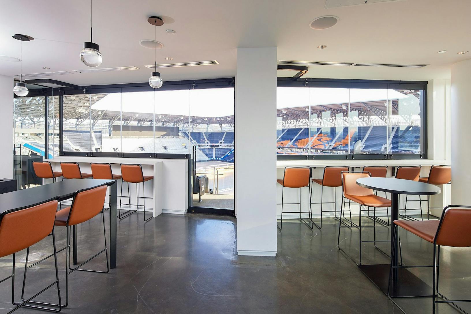 Suite with a bar with orange stools and A bar with orange stools and a Single Track Sliding view of a stadium