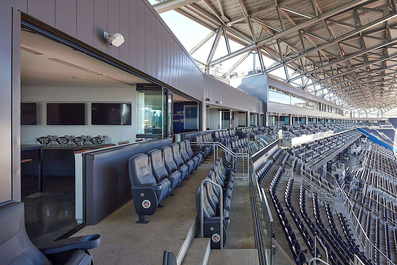 The inside of the TQL stadium with rows of seats - frameless glass panels