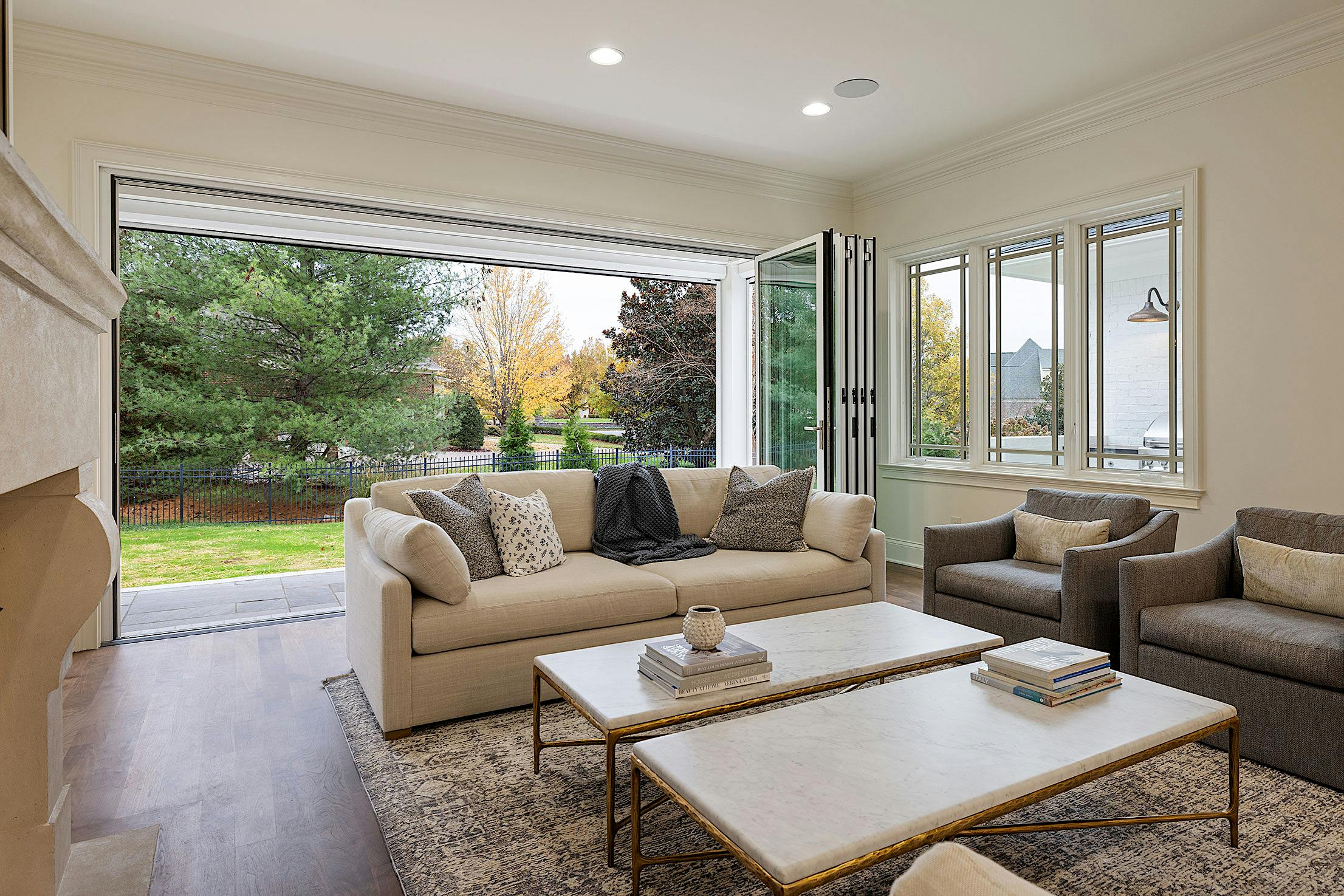 A living room with folding glass walls and a fireplace