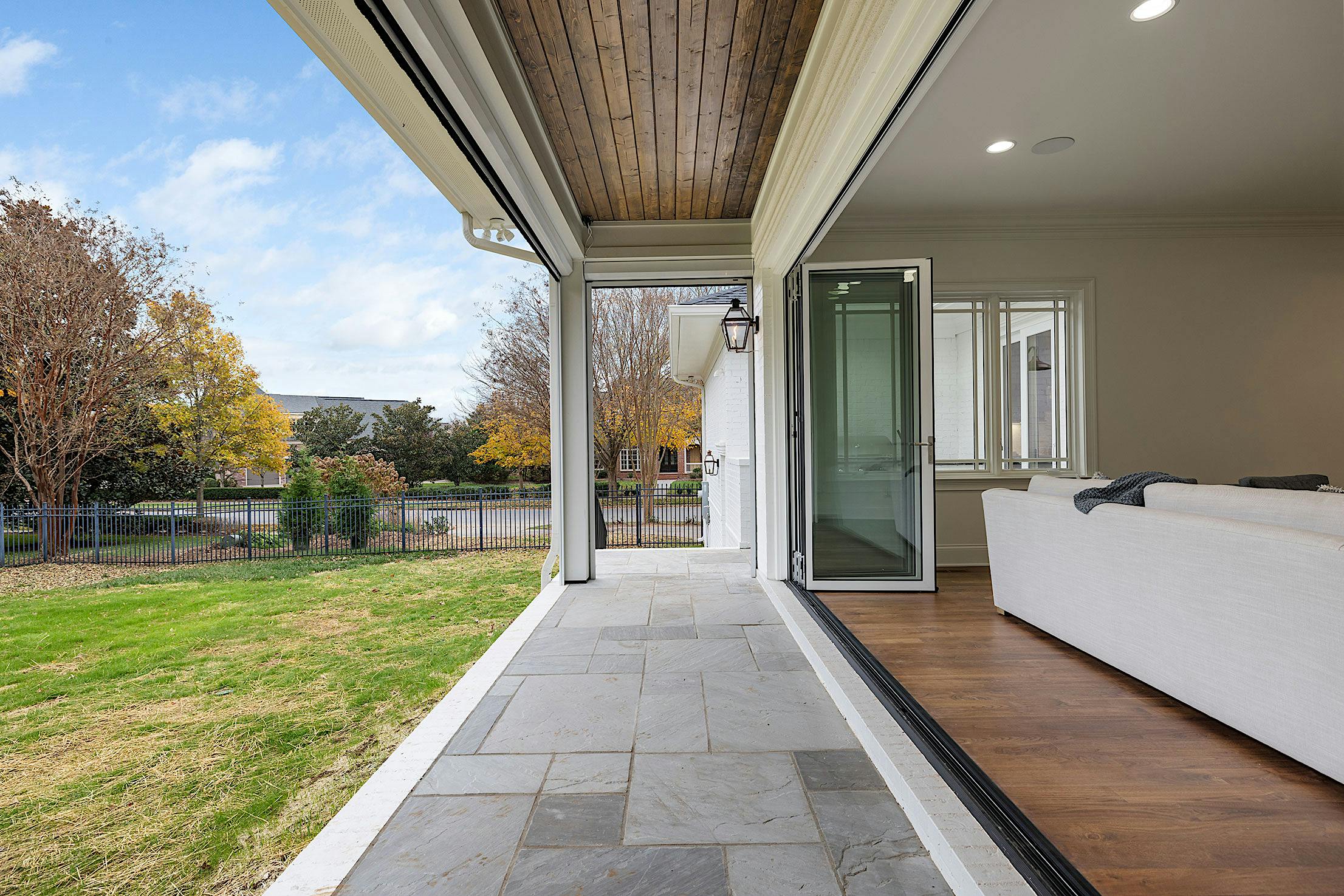 A living room with a large opening folding glass doors