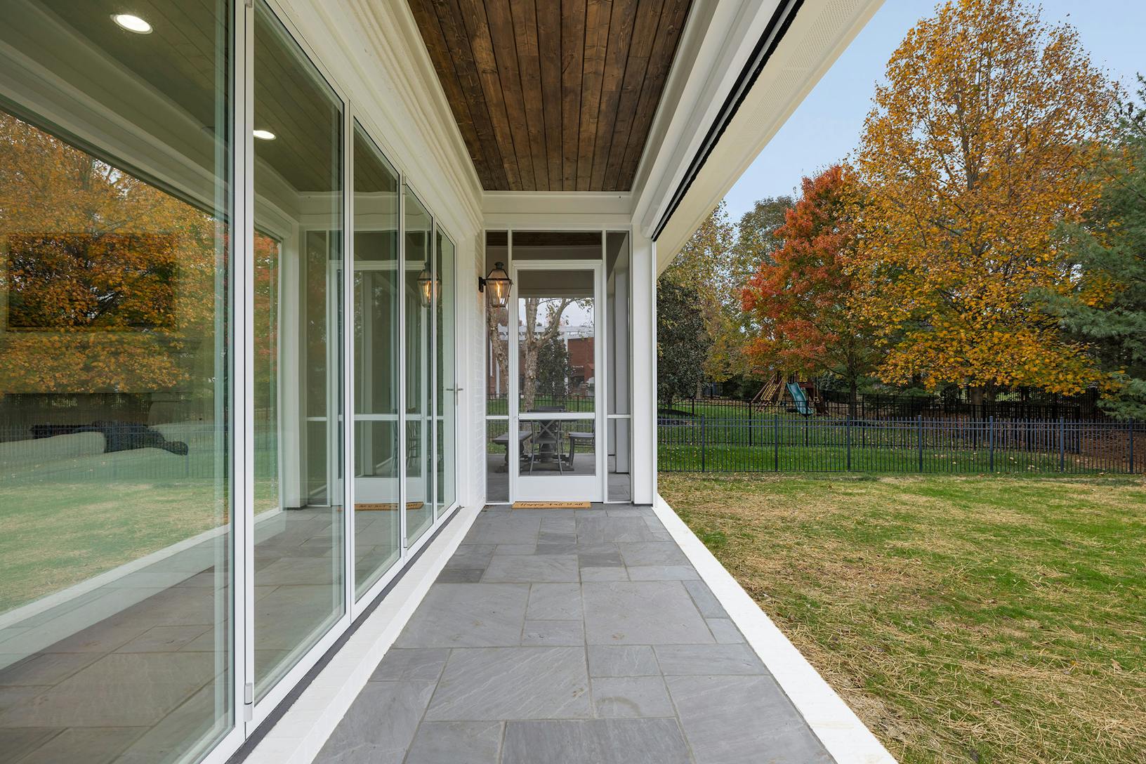 A porch with folding glass walls and a grassy area