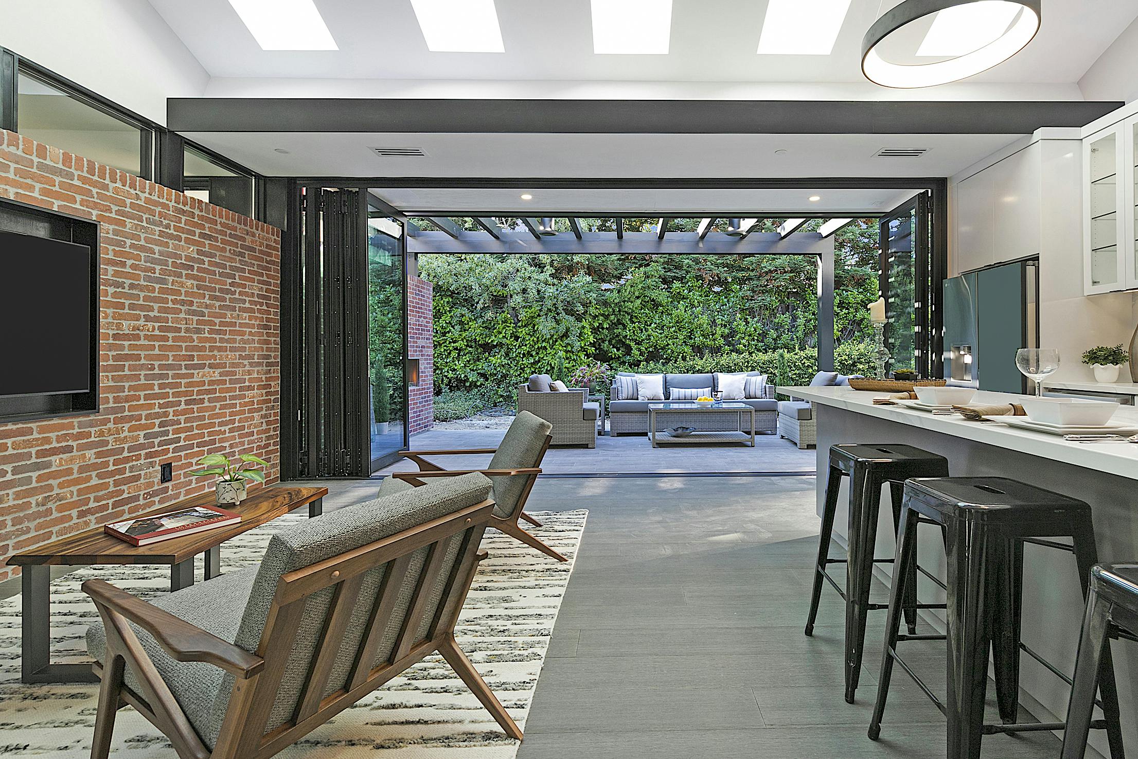 Modern ADU kitchen with a brick wall and folding glass walls