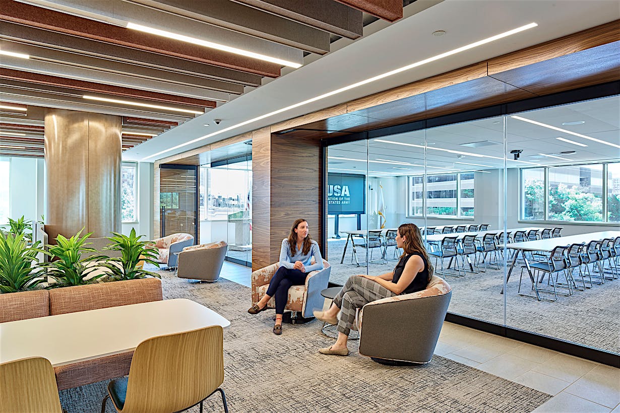 A group of people sitting in a conference room with a Frameless Glass Wall