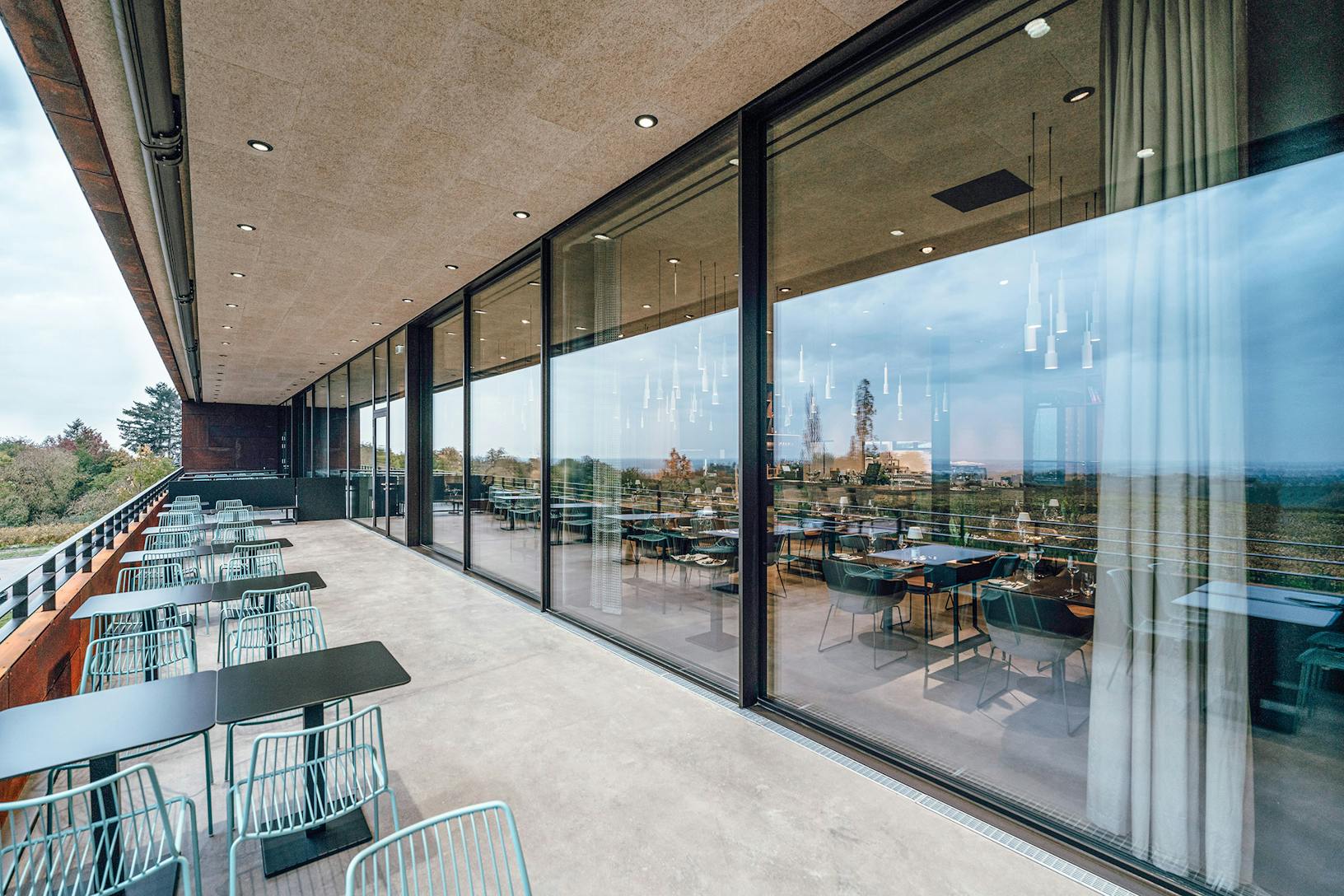 A winery with large minimal sliding glass walls, offering breathtaking views from its commercial space