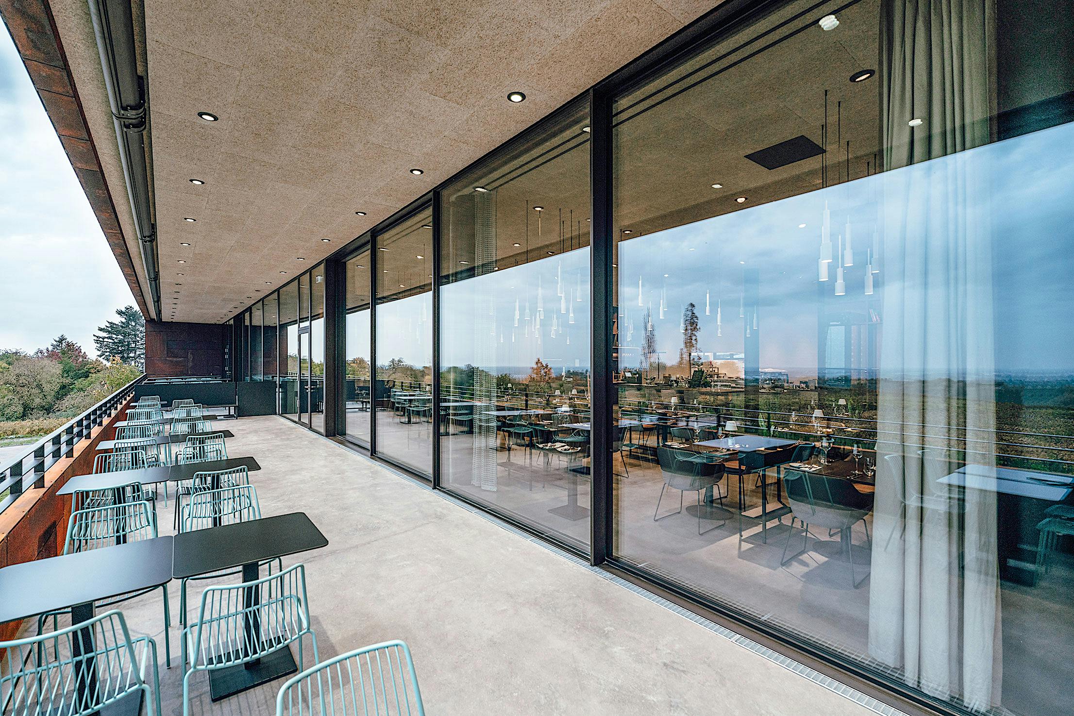 A winery with large minimal sliding glass walls, offering breathtaking views from its commercial space