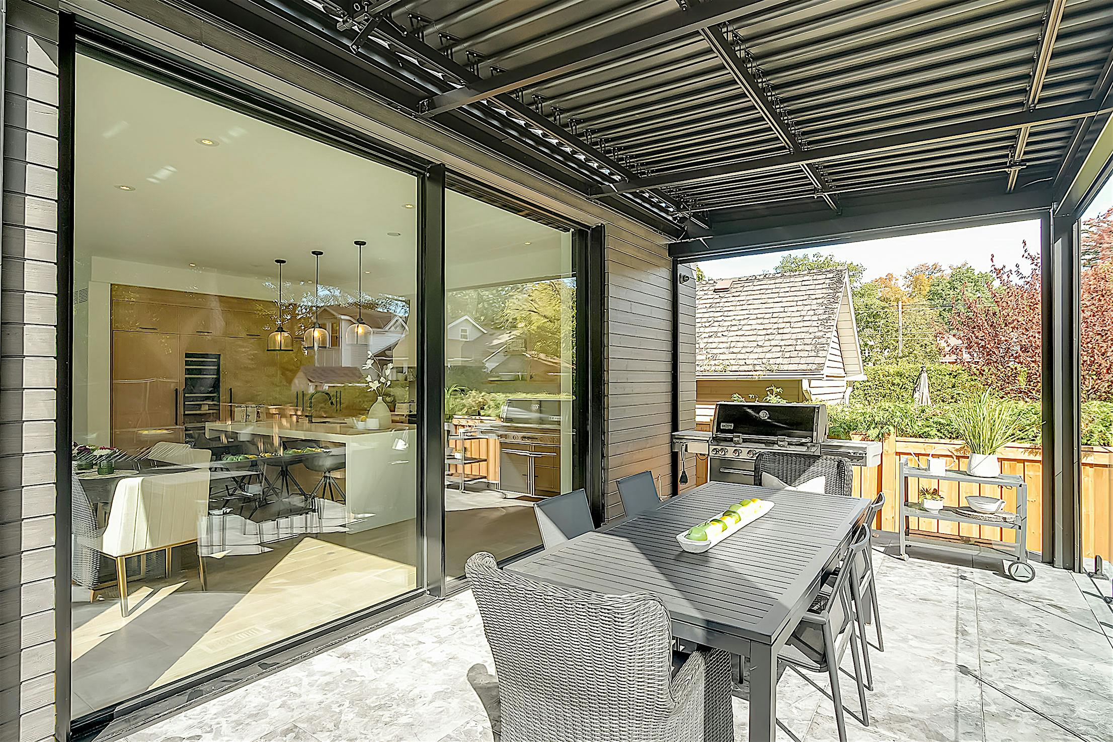 A patio with a dining table and large sliding doors