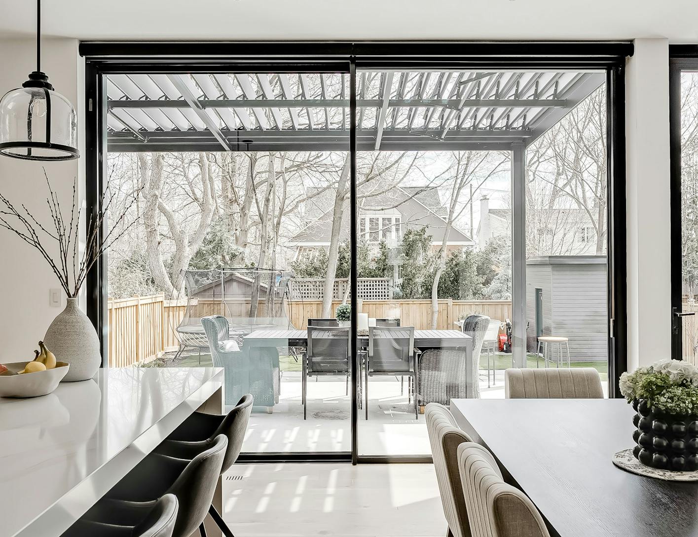 A modern kitchen with large glass doors and a dining table