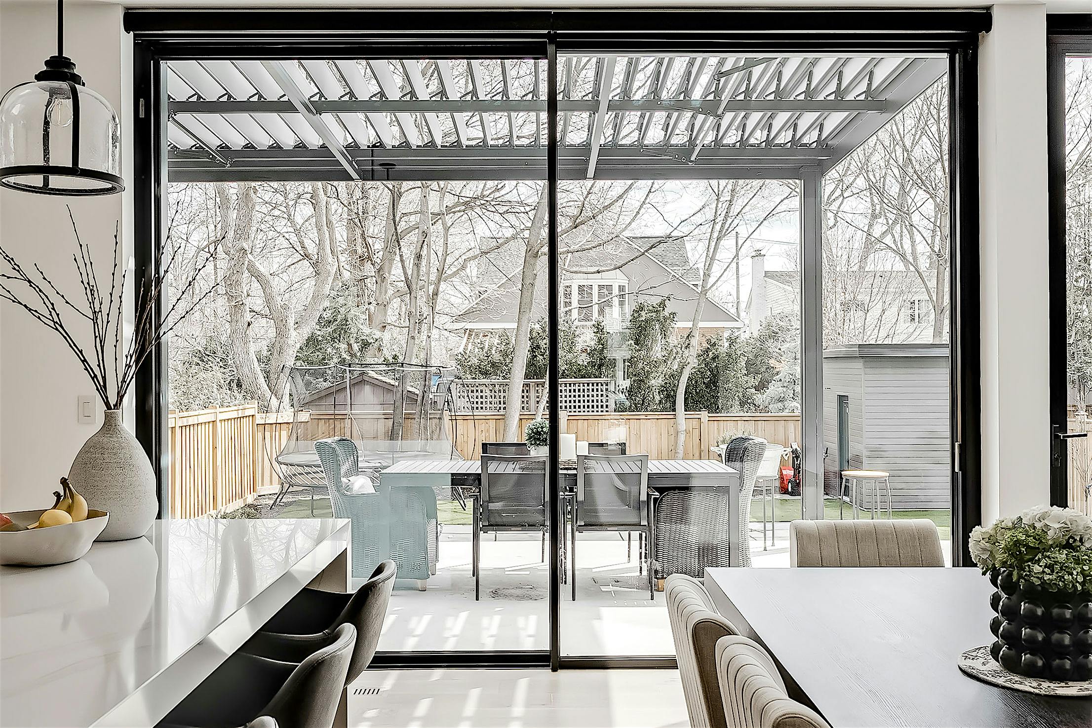 A modern kitchen with large glass doors and a dining table