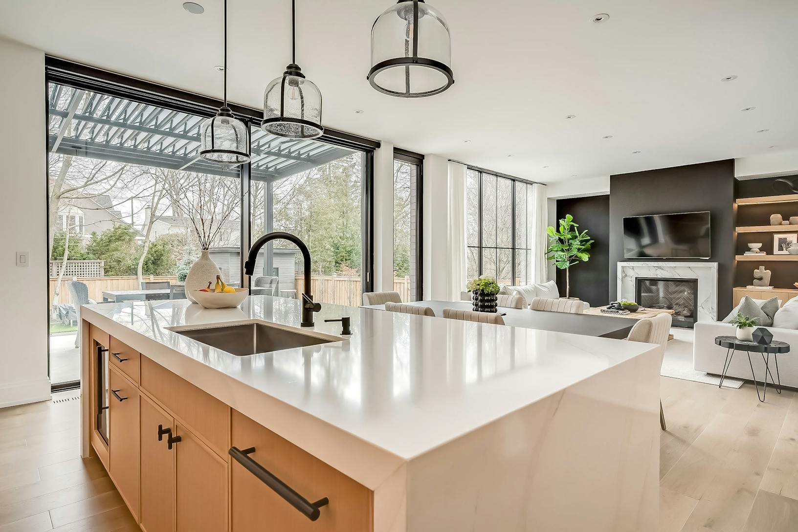 A modern kitchen with white counter tops and stainless steel appliances featuring minimal sliding glass walls
