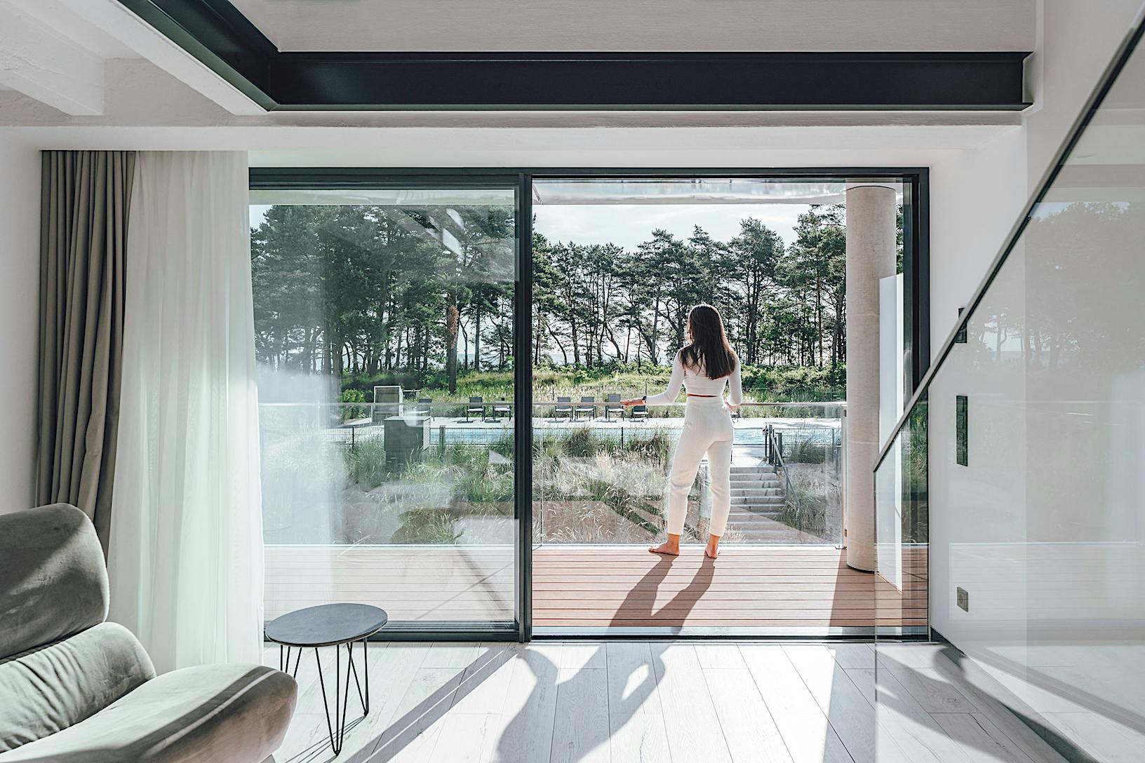 A woman standing in front of a minimal sliding door in a multi-family balcony