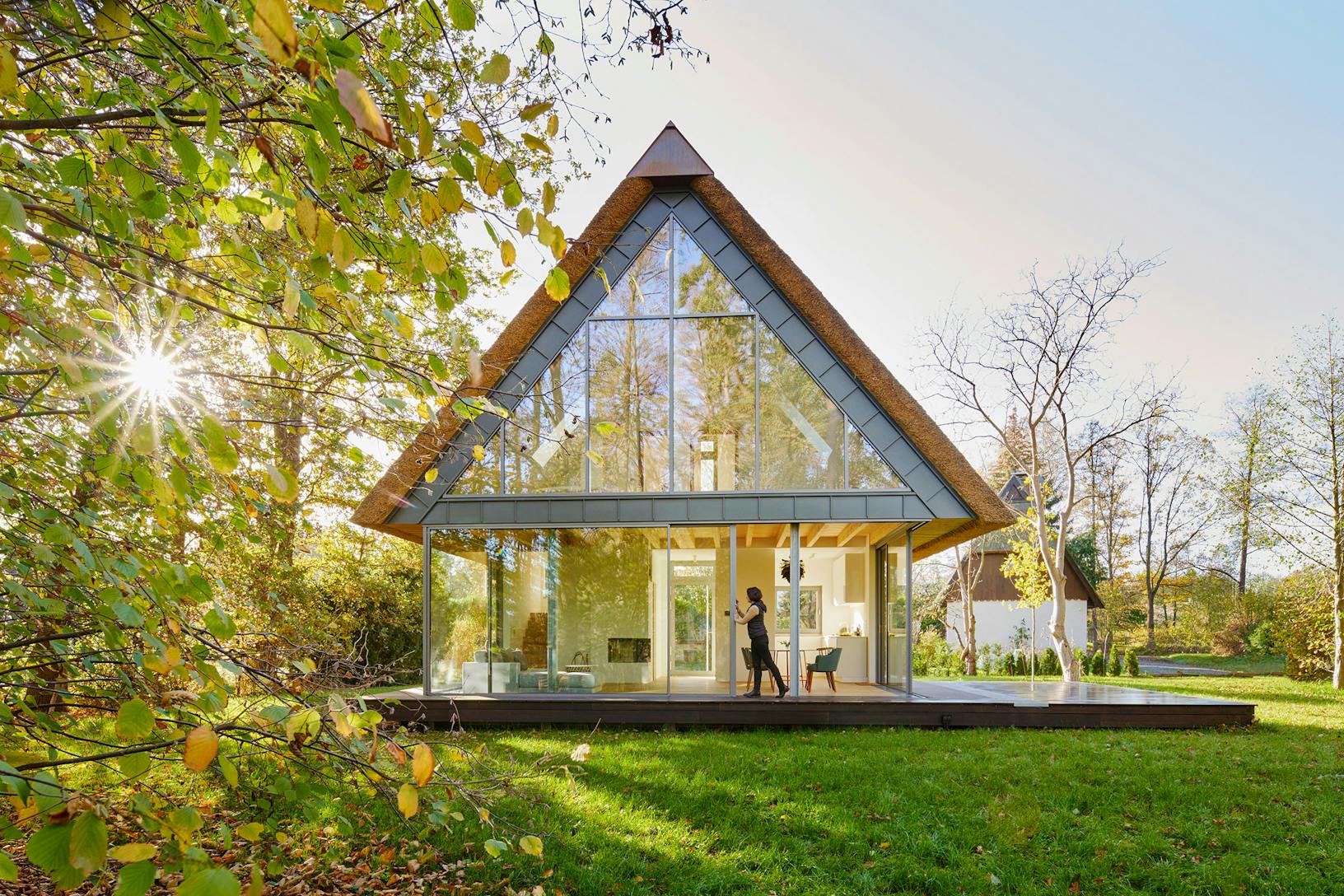 A contemporary glass house featuring sleek sliding patio doors