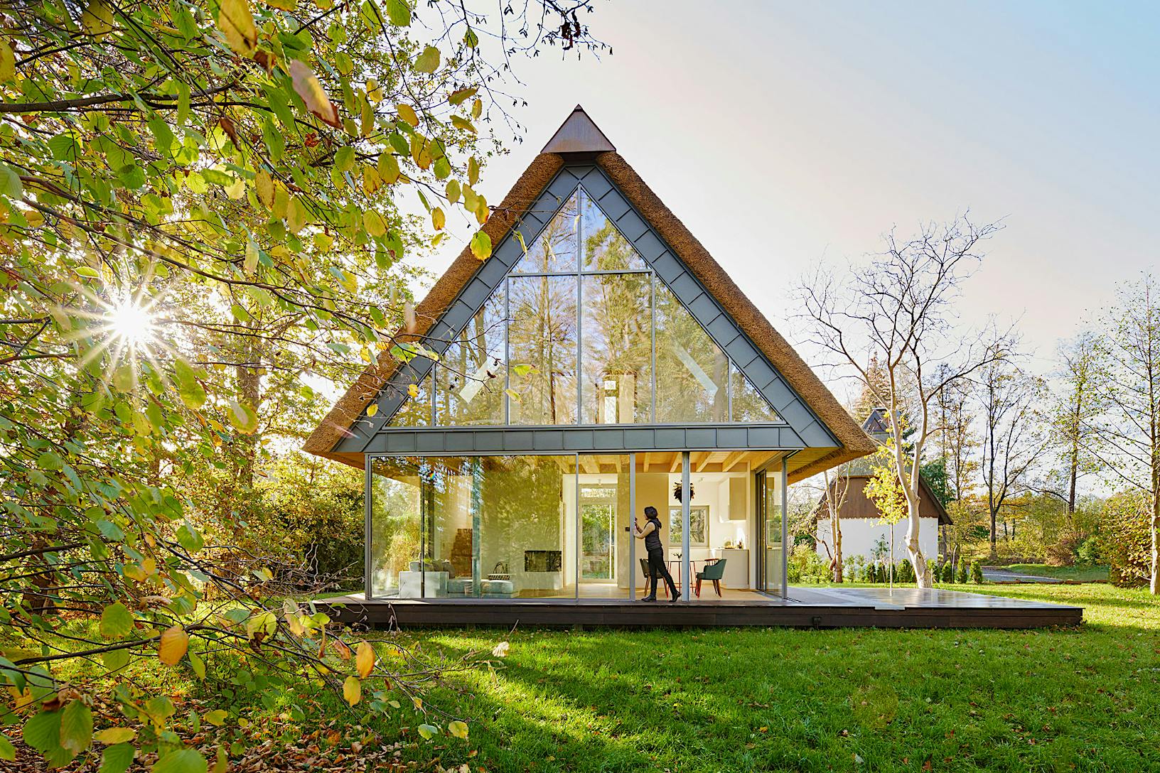 A contemporary glass house featuring sleek sliding patio doors