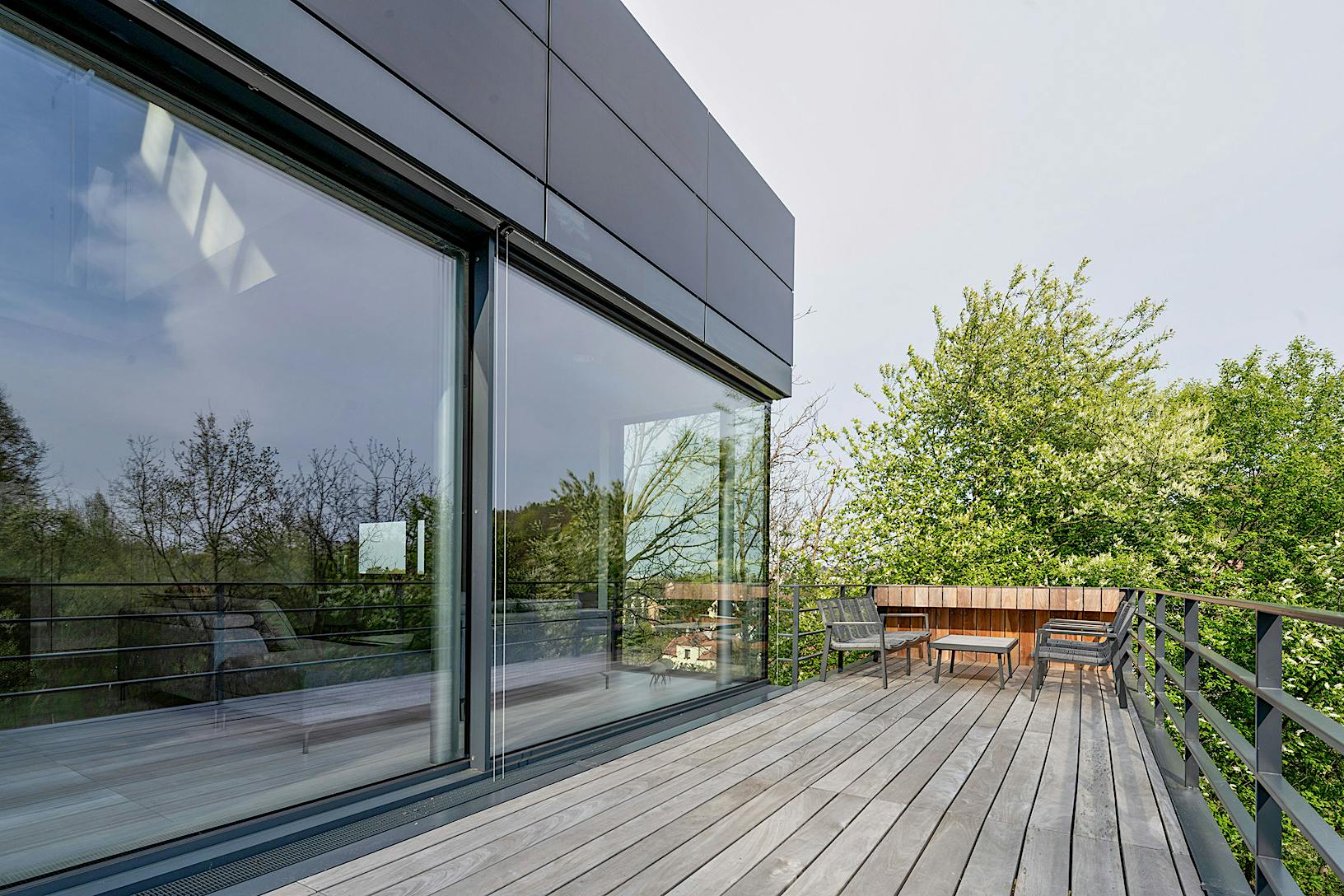 A modern house with a wooden deck and large sliding glass doors