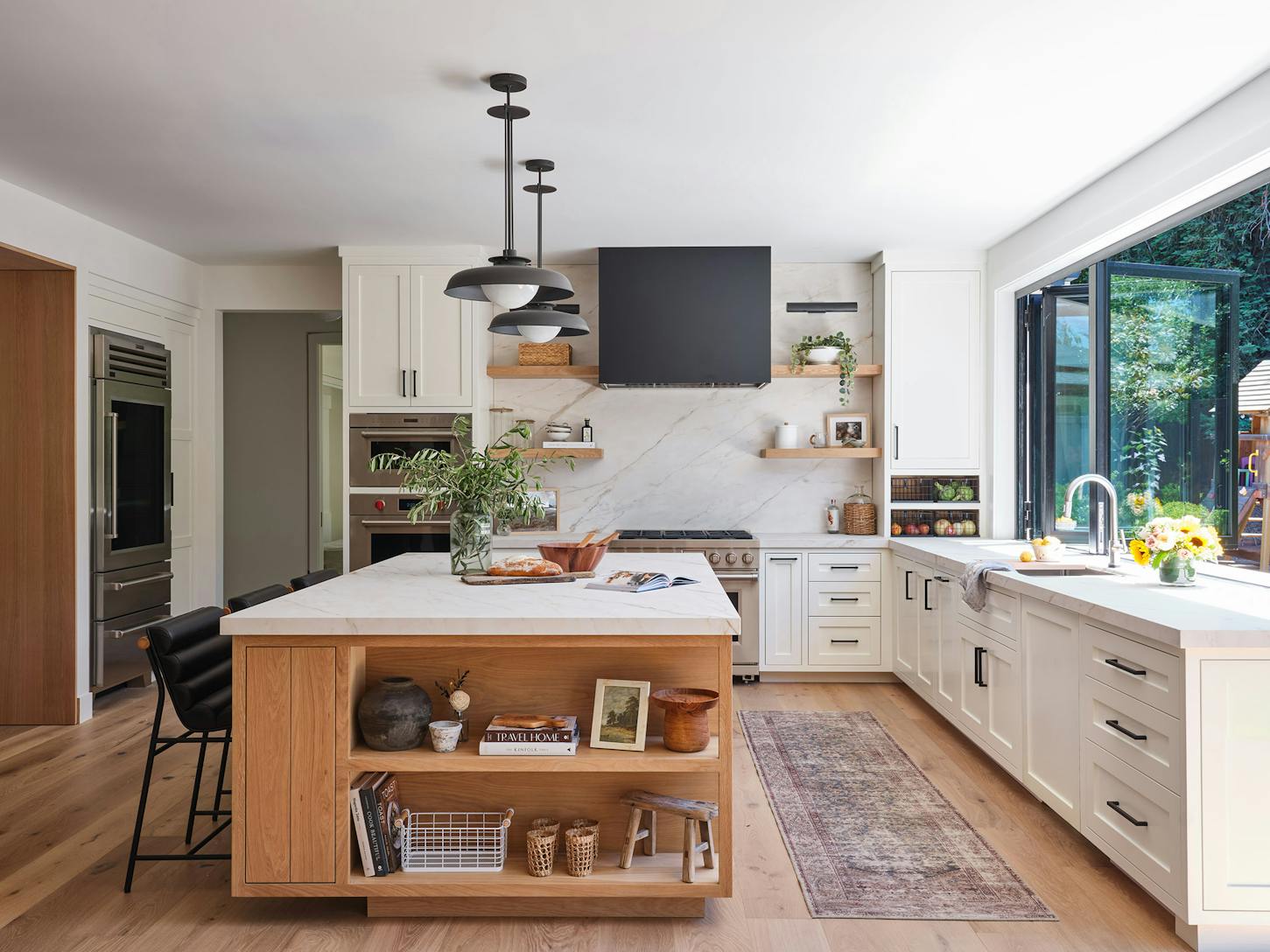 A modern kitchen with a view of the outdoors through a kitchen transition systems