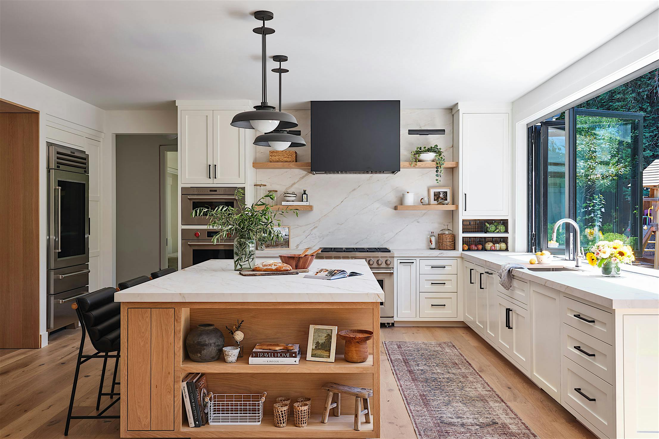 A modern kitchen with a view of the outdoors through a kitchen transition systems