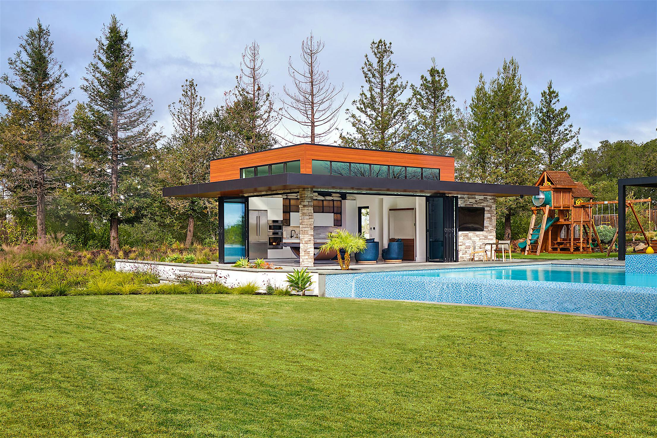 A pool house with folding glass walls