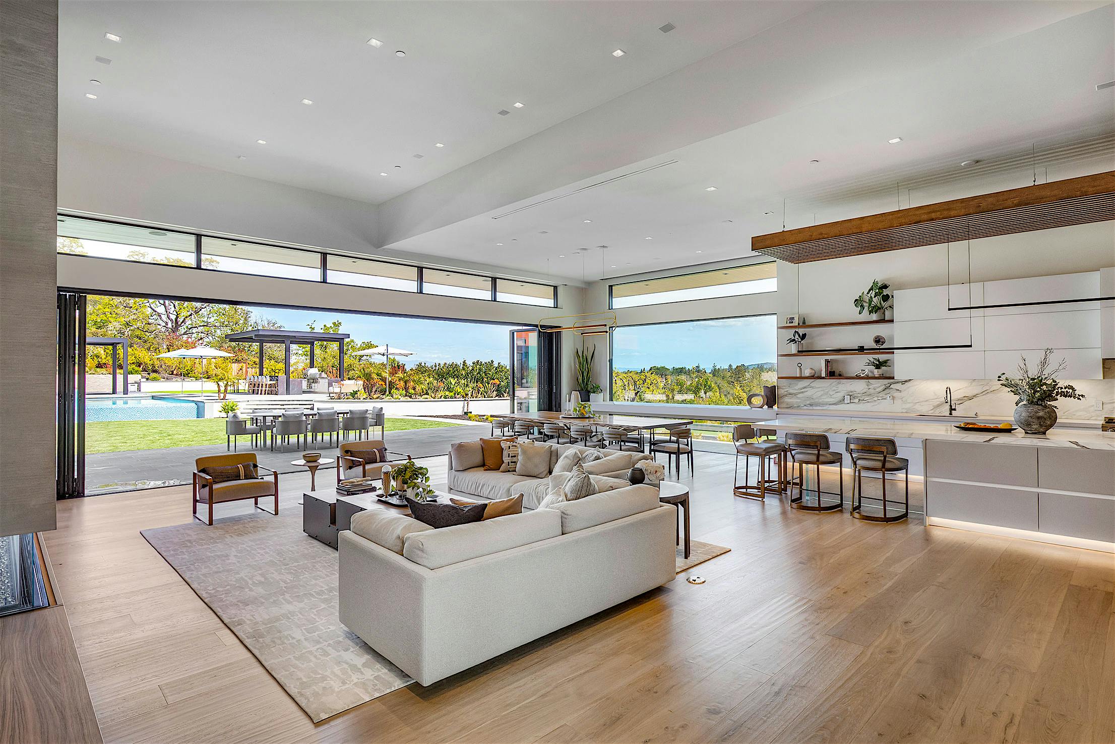 A modern living room with large opening glass walls