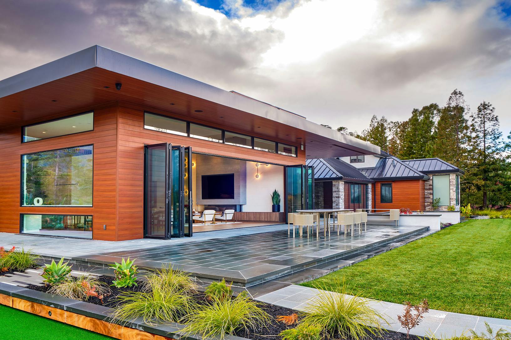 Contemporary house with Generation 4 bifold glass walls embracing a green lawn