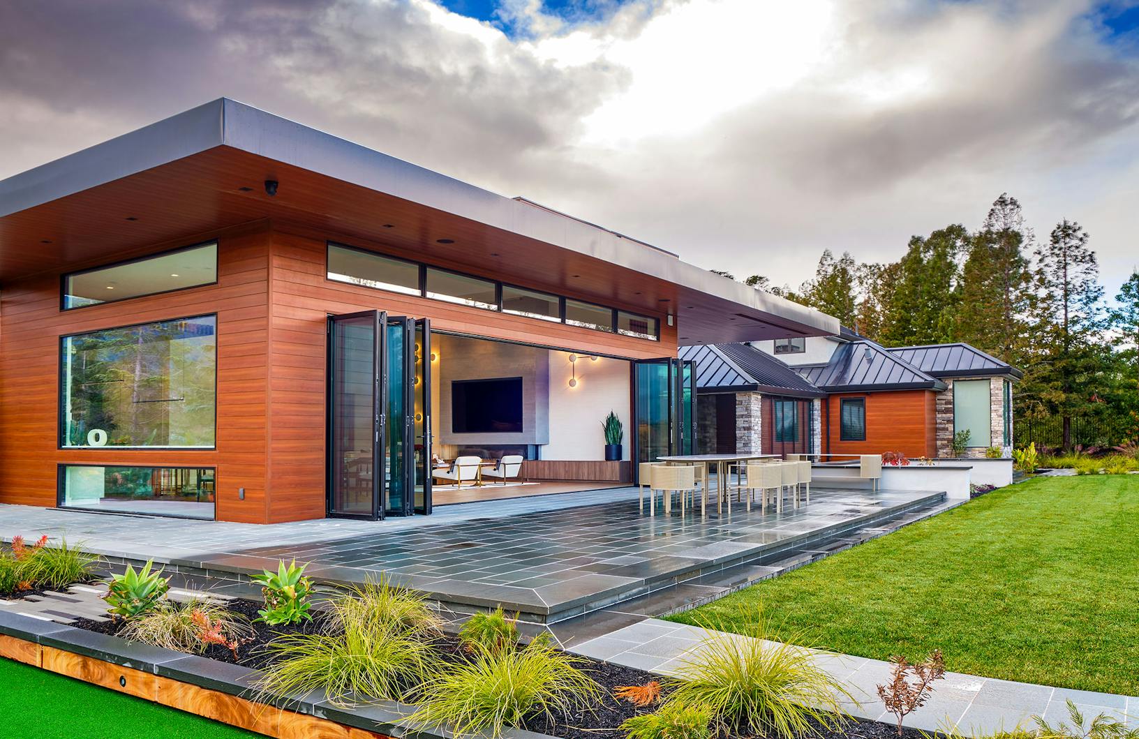 Contemporary house with Generation 4 bifold glass walls embracing a green lawn