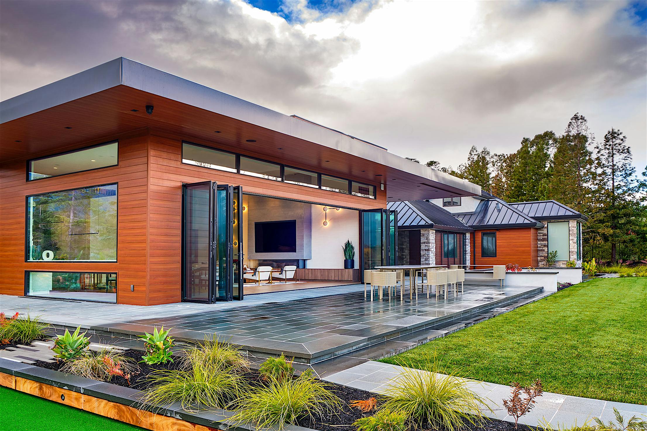 Contemporary house with Generation 4 bifold glass walls embracing a green lawn