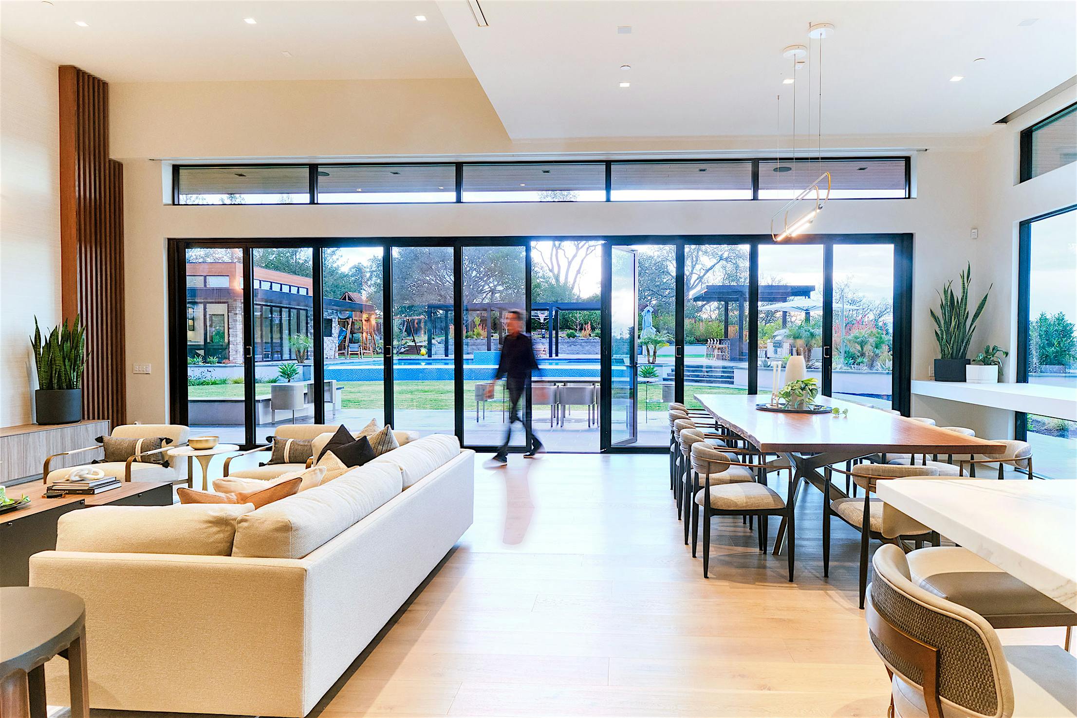 A modern living room featuring aluminum framed bifold glass walls