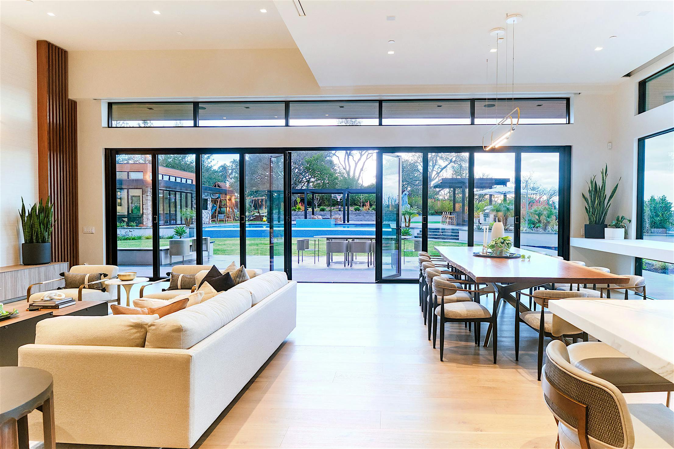 A modern living room with outdoor lifestyle and bifold glass walls