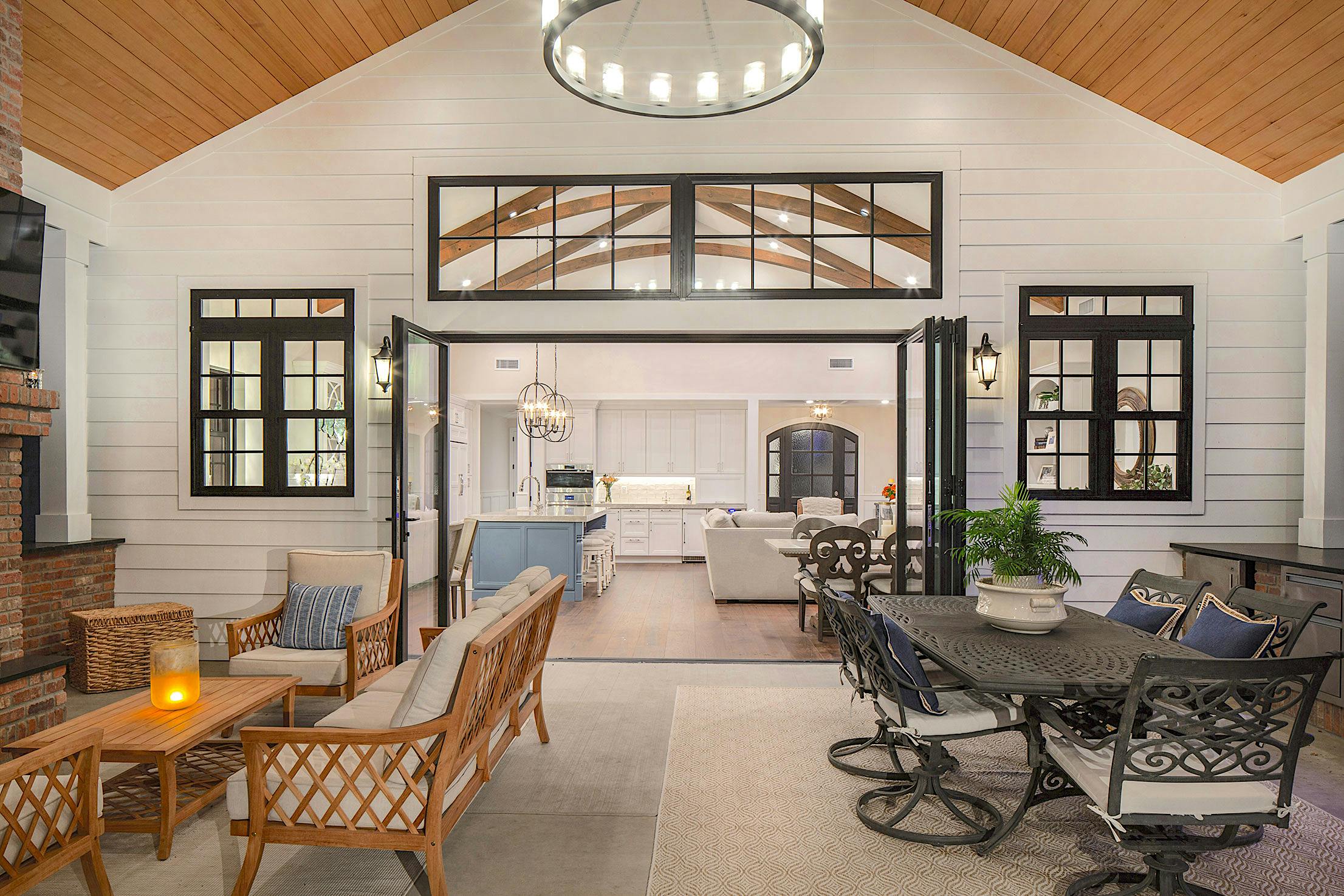 A large living room with glass walls, a fireplace, and dining table