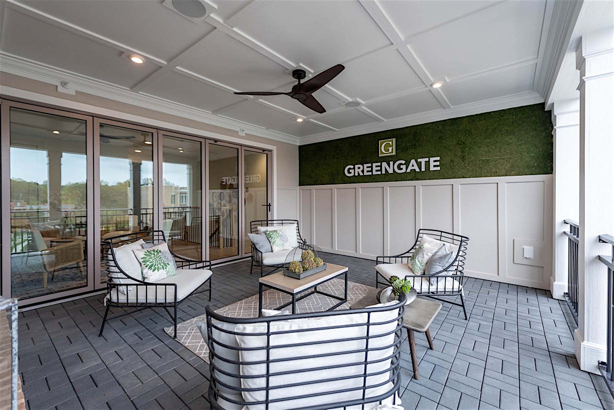 A furnished outdoor patio area with sleek glass accordion doors that lead to the interior.