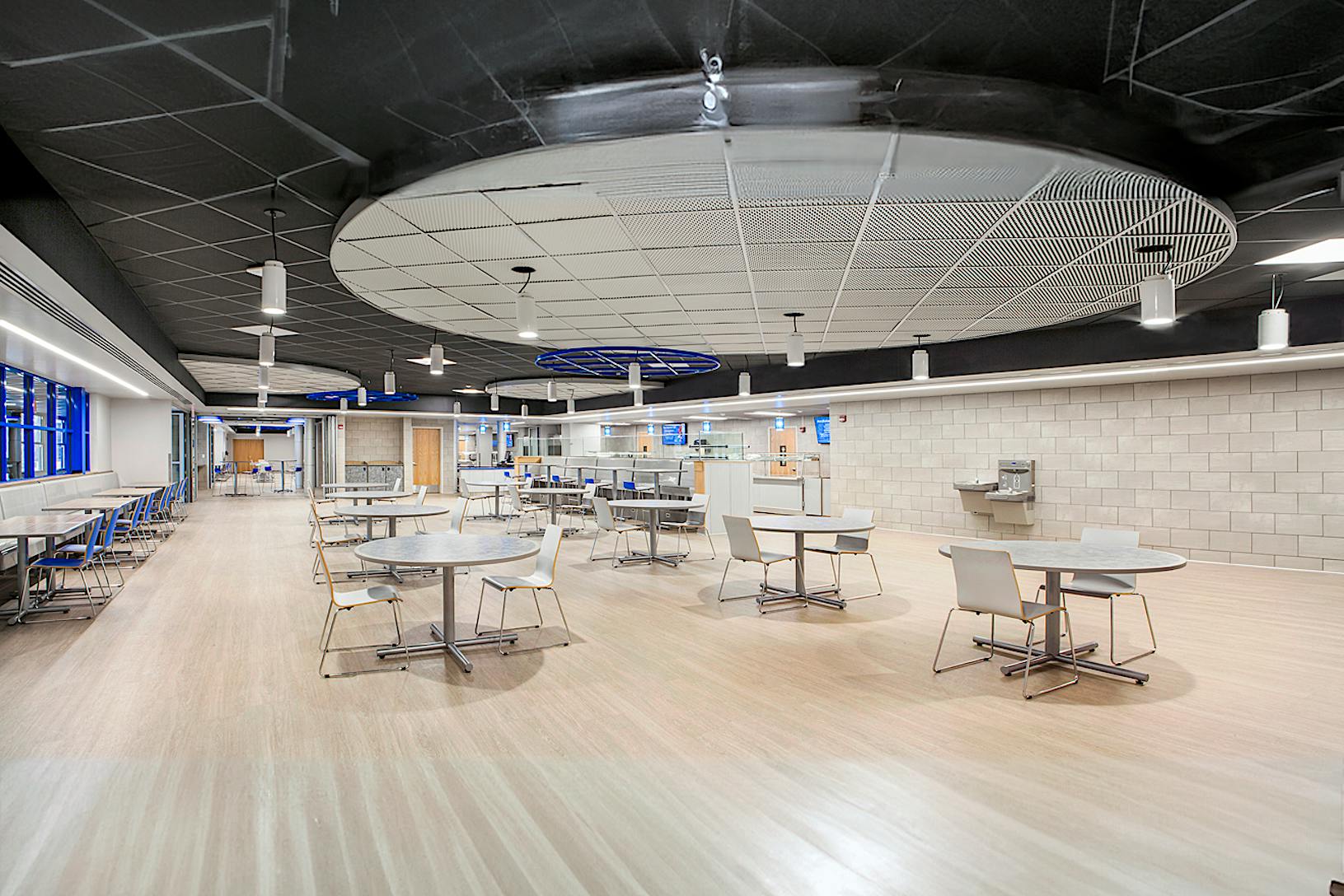 A spacious, modern cafeteria features folding walls that offer flexibility for various events and gatherings.