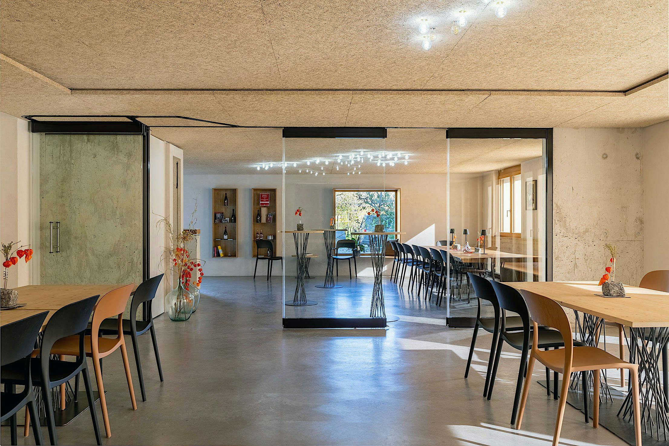 A modern, spacious wine tasting area features large sliding glass doors bringing light to the room.