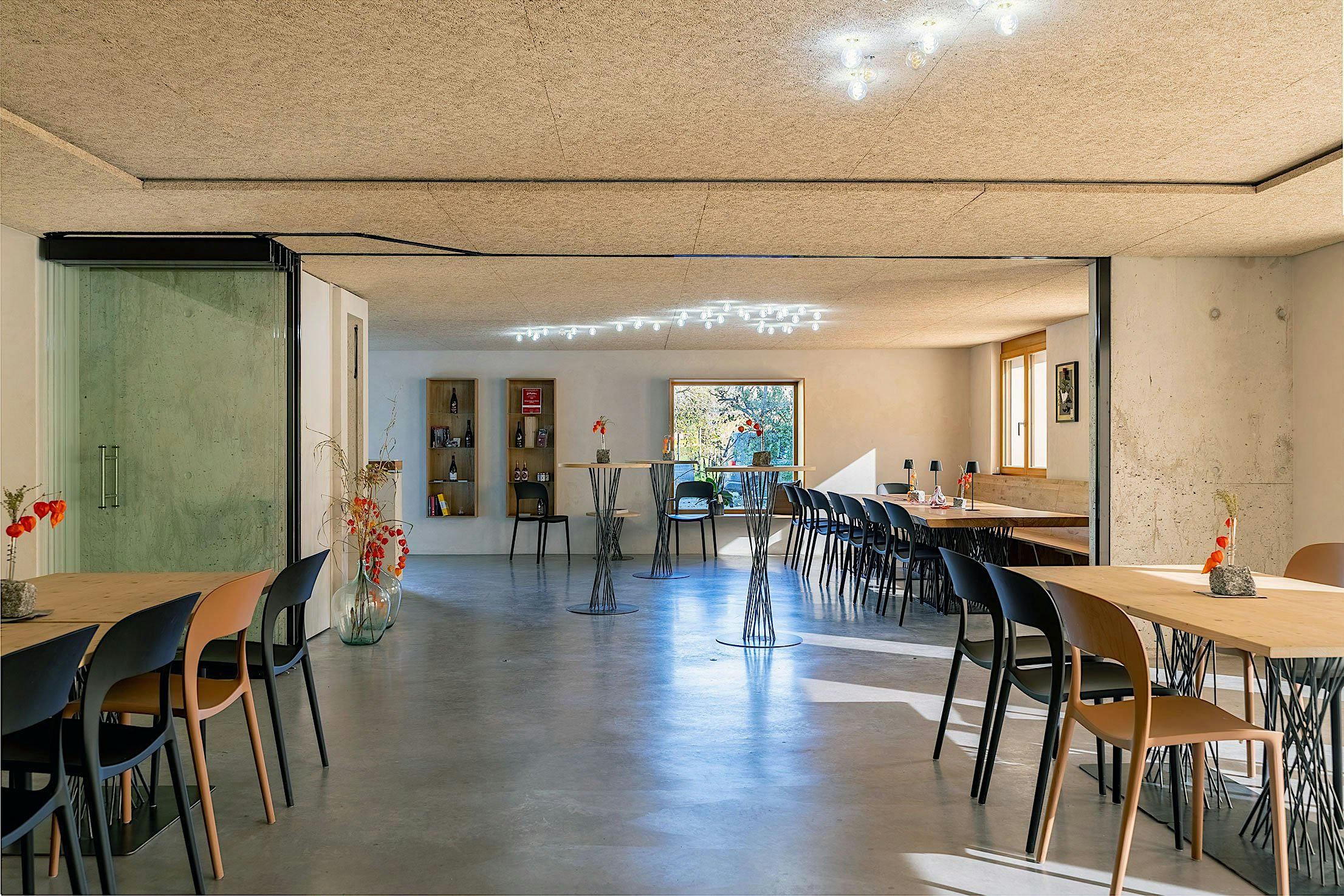 A modern wine tasting room with featuring sliding doors stacked in a parking bay.