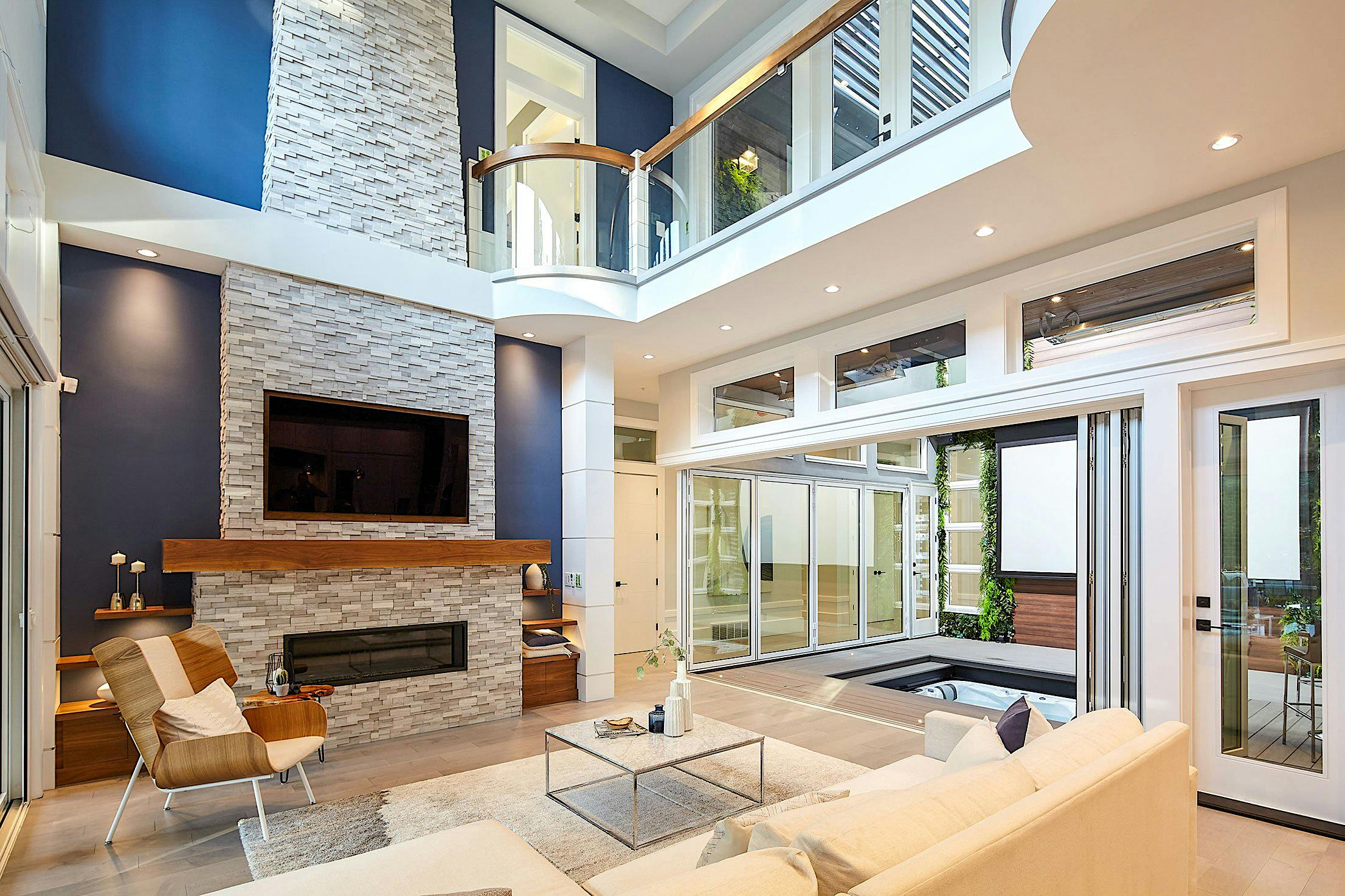 Accordion glass patio doors transform this modern living space, opening indoor area to adjacent patio with sleek style