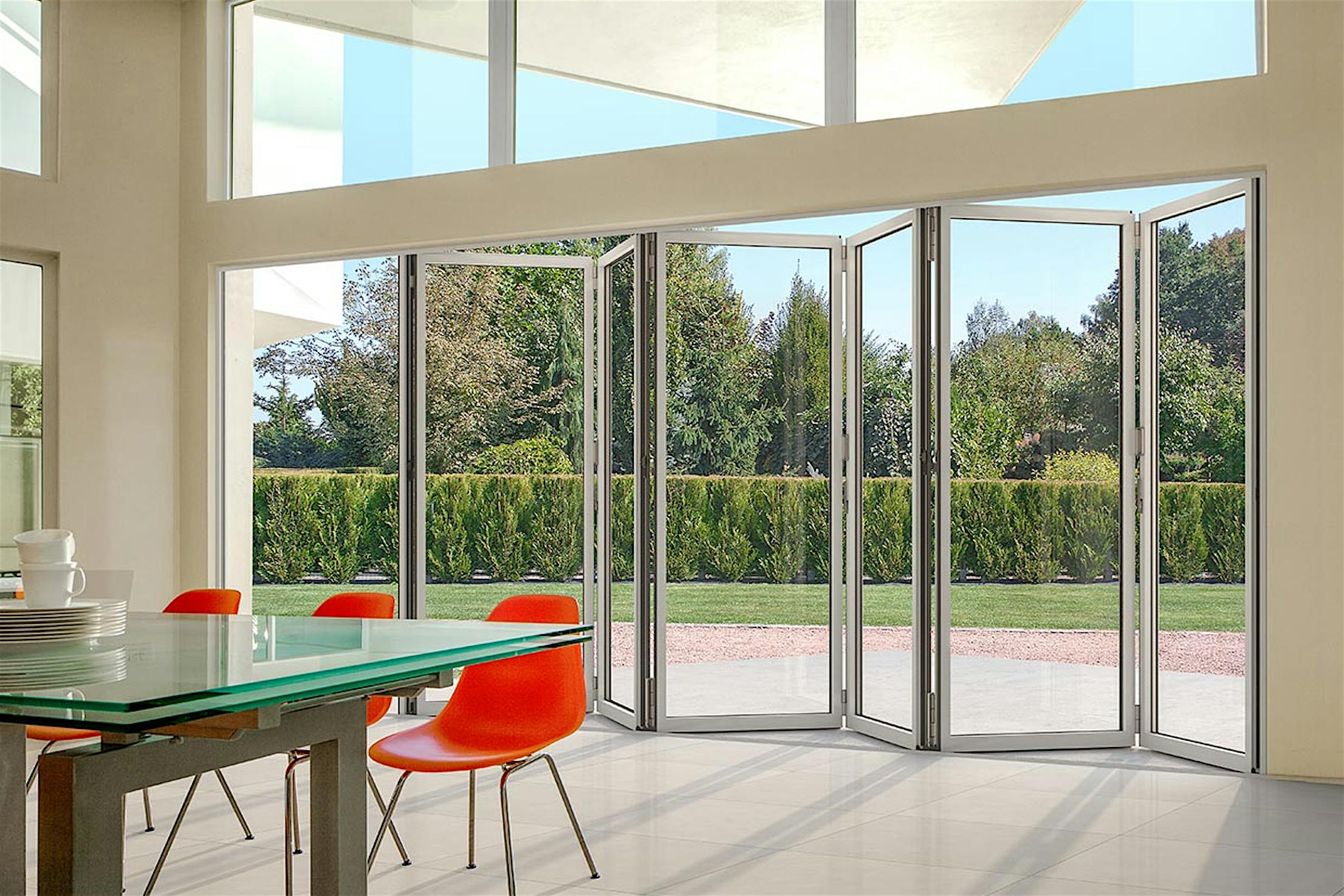 A dining room with a glass sliding door, also known as a folding patio door