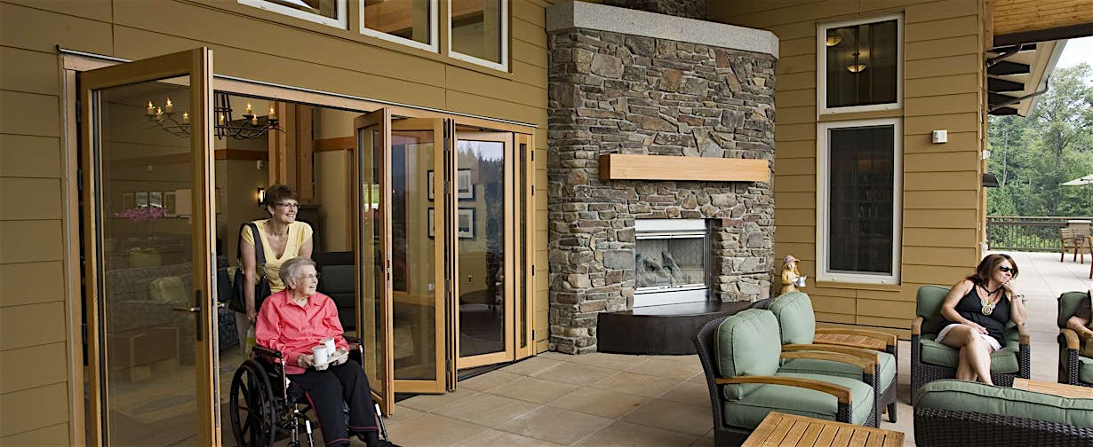 a person in a wheelchair in a room with a fireplace - commercial moveable glass walls 