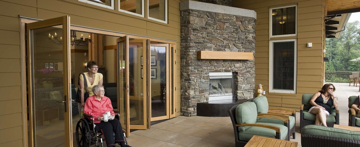 a person in a wheelchair in a room with a fireplace - commercial moveable glass walls 