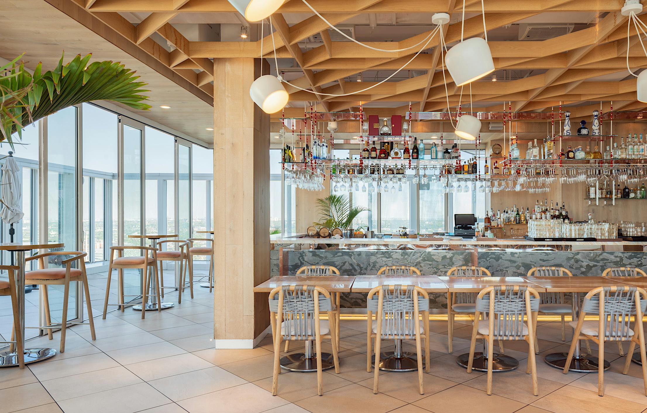 Opening glass doors with ADA compliance in modern bar featuring city views and stylish interiors.