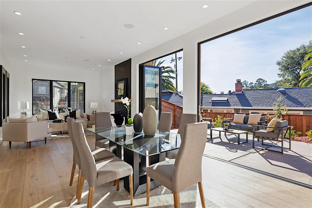 Modern open-plan living and dining area with bifold glass doors leading to a patio.