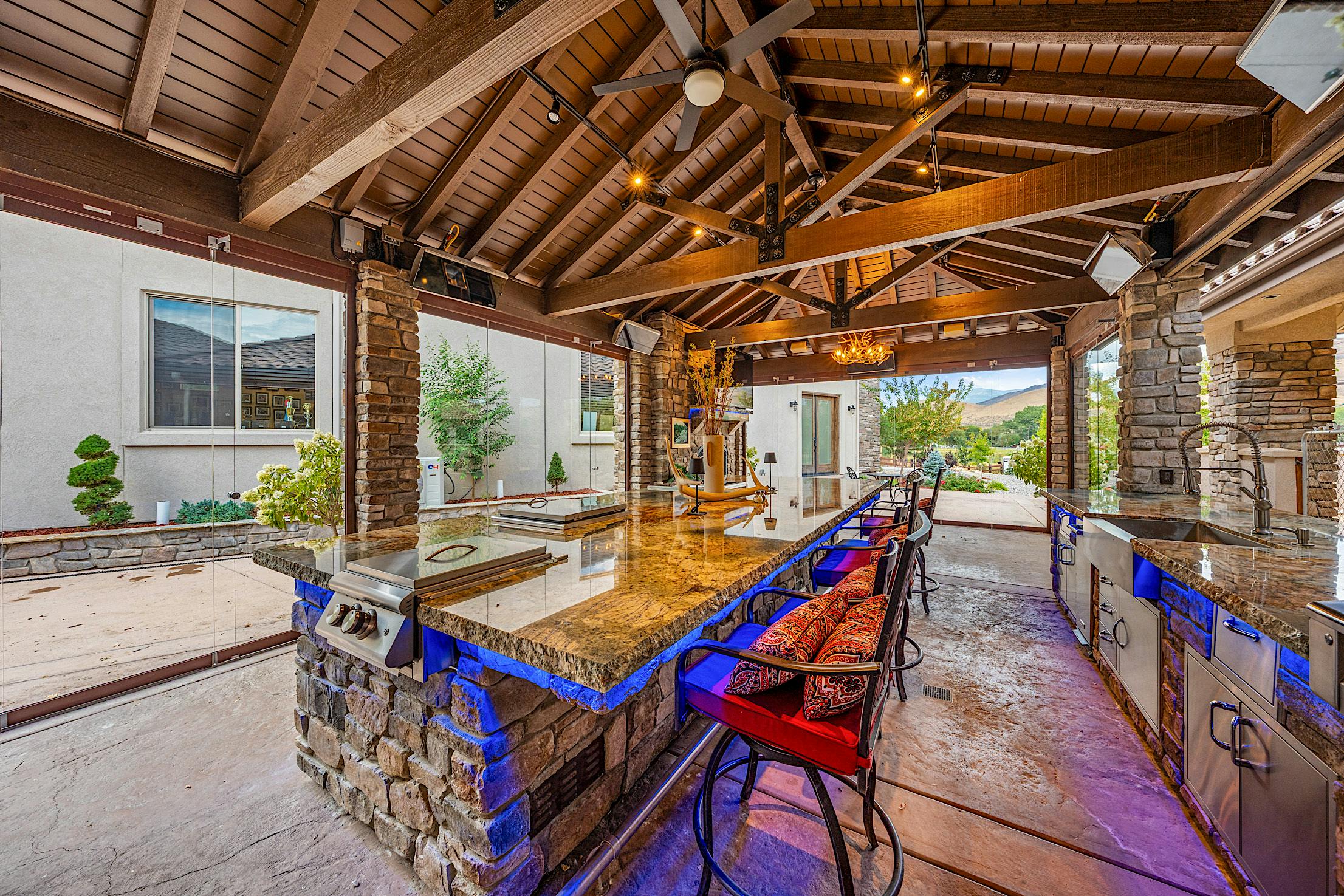 frameless movable glass doors create a luxury outdoor kitchen year-round